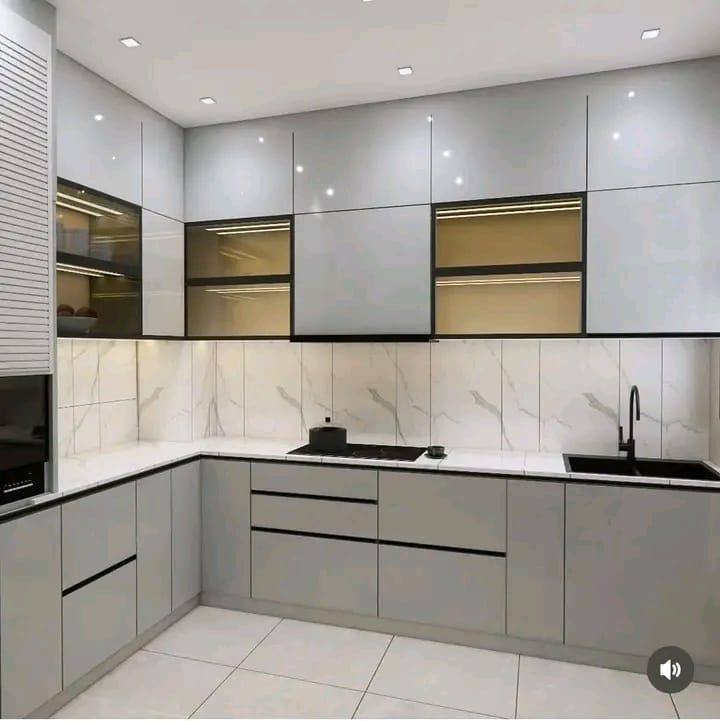 Modern open plan modular kitchen with grey gloss cabinetry, white quartz countertops, and marble splashback in Nairobi