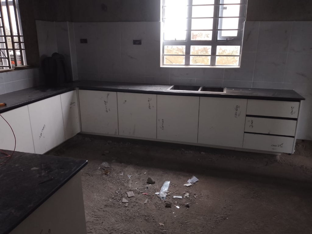 L-Shaped Granite & White Kitchen Cabinetry Installation - Residential interior fit-out in Utawala, Nairobi by BenPhil Interiors